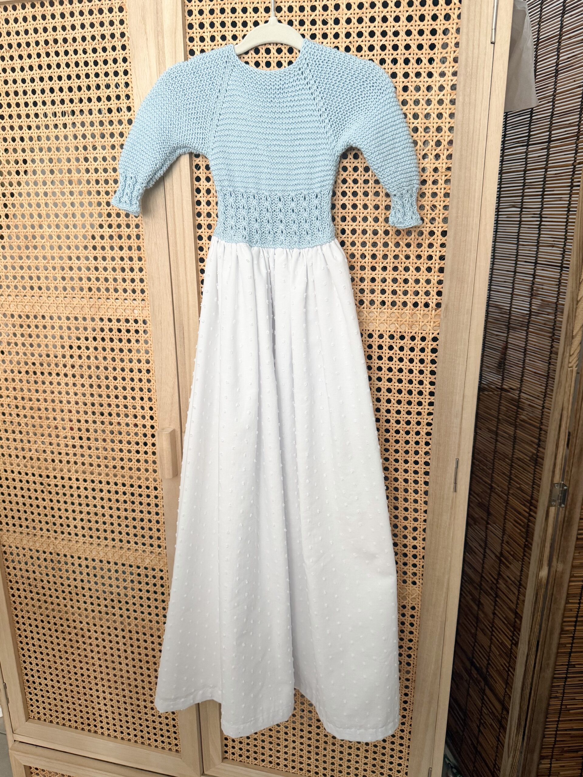 Faldón de punto en algodón celeste con plumeti